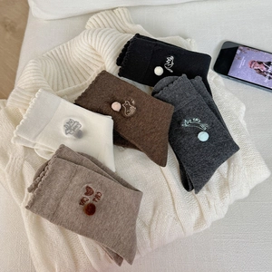 Close-up of cute cat embroidery and 3D pom-poms on ruffled cotton crew socks in five colors