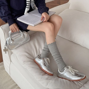 Silver metallic sneakers and matching handbag set for women in a stylish lifestyle setting