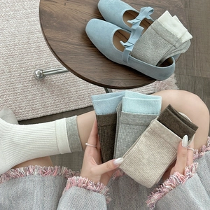 Detail of ribbed knit crew socks in morandi tones with color block cuffs and soft texture