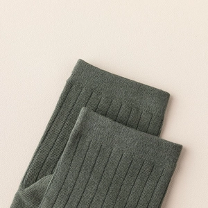 Detail of ribbed cuff on dark green cotton five-finger socks with vertical knit texture