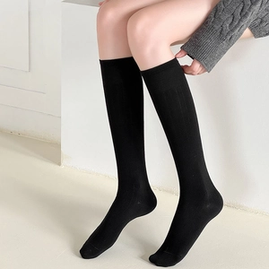 Détail de chaussettes hautes noires avec une texture classique en maille côtelée