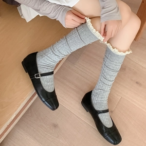 Detail of grey calf-high socks with white lace trim and vertical ribbing texture