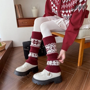 Dettaglio degli scaldamuscoli spessi in maglia con motivi nordici a fiocchi di neve