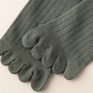 Detail of ribbed dark green five-finger socks showing the toe separation design