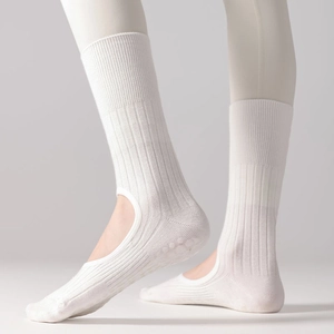 Detail of white ballet-style yoga socks featuring non-slip silicone grips and stirrup design