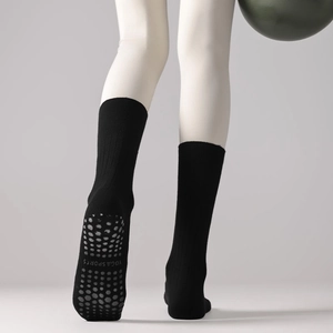 Close-up of non-slip silicone grips on black yoga socks with yoga sports text