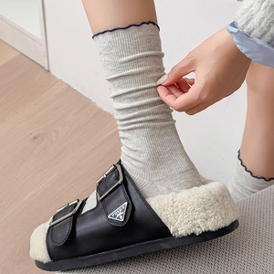 Détail de chaussettes côtelées gris clair avec bordure ondulée bleue et maille fine