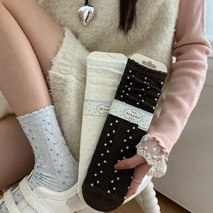Close-up of ribbed knit cotton socks with polka dots and ruffled edge detailing
