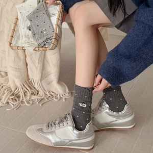 Detail of grey polka dot crew socks with a cute cat MEOW label and knit texture