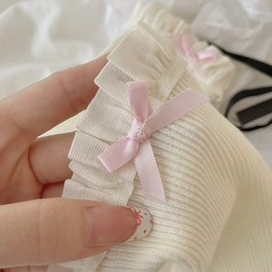 Detailansicht weißer gerippter Socken mit zarter Spitze und einer rosa Satinschleife