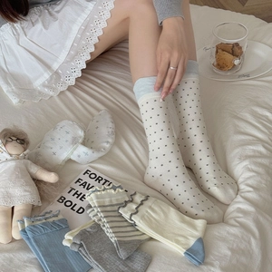 Detailed view of women's cotton crew socks with polka dots and ruffled lace trim texture
