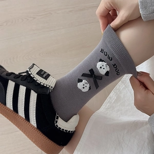 Detail of grey knitted mid-calf socks with cute panda pattern and black 3D bow accent