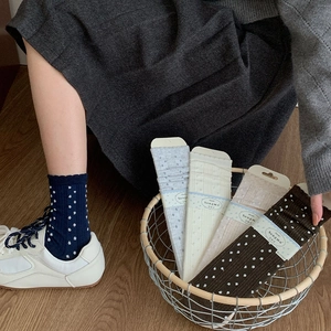 Detail of vintage navy blue knit socks with white polka dots and delicate lace cuffs
