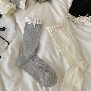 Detail von Ballet-Spitzensocken mit rosa Satinschleifen in den Farben Grau, Weiß und Schwarz