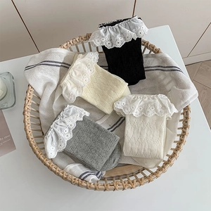 Detailed view of four pairs of knitted lace trim socks in black, yellow, grey and off-white