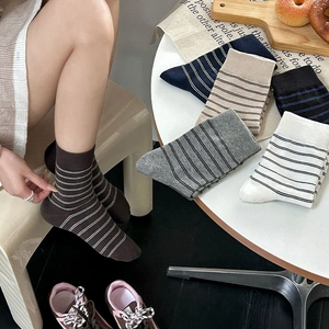 Detailed display of striped cotton mid-tube socks in various colors with lifestyle props