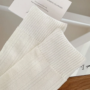 Detail view of white ribbed knit socks showing high-quality fabric texture and cuffs