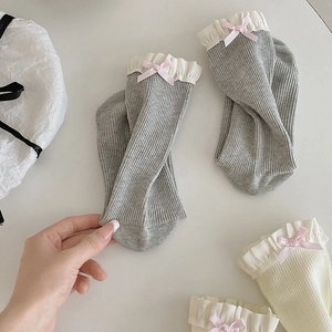 Detailansicht der Spitzenborte und rosa Satinschleifen an gerippten Ballett Socken