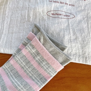 Vista dettagliata della trama a maglia di cotone delle calze a righe grigie e rosa