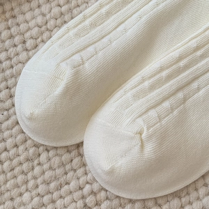 Detailed macro view of white vertical stripe knit socks showing premium toe craftsmanship