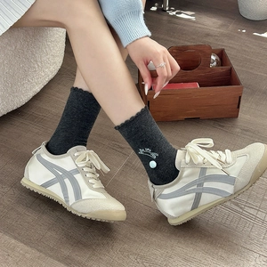 Cute white cat embroidery socks with 3D pom-pom and lace trim shown with sneakers