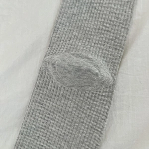 Close-up of light grey ribbed knit socks showing durable reinforced heel construction