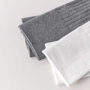 Detailed macro view of ballet yoga socks featuring ribbed knit texture in white and grey colors