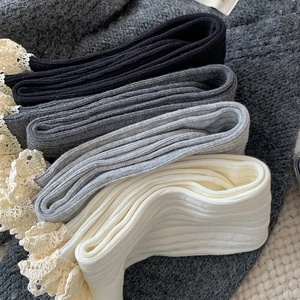 Close-up of ribbed knit calf socks in four colors with delicate lace trim detailing