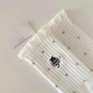 Detailed view of white ribbed socks with gray polka dots and cute cat embroidery
