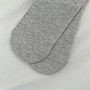 Close-up of grey knitted socks showing detailed vertical ribbed texture and soft cotton fabric
