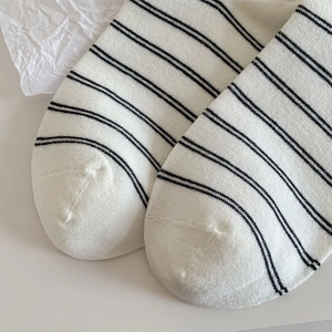 Primo piano di calze di cotone bianco a righe nere con trama a maglia e cucitura