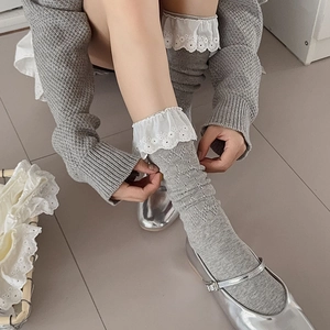 Detailed macro of grey ribbed cotton socks with delicate white lace embroidery trim