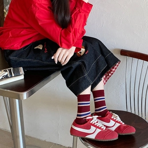 Retro red and blue striped crew socks with vintage sporty sneakers and black denim skirt