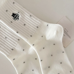 Detail of white cotton socks with cat embroidery and grey polka dots in ribbed texture