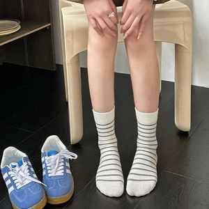 Classic white crew socks with black horizontal stripes for a minimalist casual look
