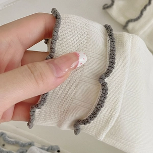 Detailed view of elastic ruffled cuff on white ribbed cotton crew socks for women