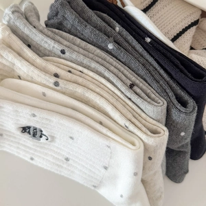 Detailed close-up of cat embroidery and polka dot patterns on rib-knit crew socks