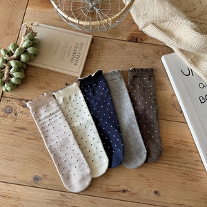 Détail de cinq paires de chaussettes à pois avec bords à volants en plusieurs couleurs