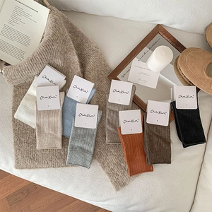 Detailed view of colorful ribbed cotton socks with minimalist retail paper packaging