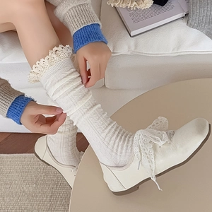 Detail of cream calf socks with lace trim and vertical knit pattern in retro style