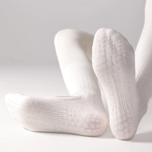 White ballet-style yoga socks with non-slip silicone grips on the sole shown on model