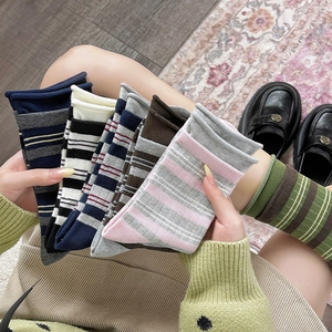 Dettaglio di calze a righe in cotone con bordo arrotolato in vari colori stile collegio