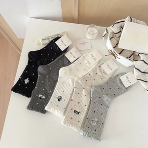 Detail of five polka dot socks with wave edges and cat embroidery in various colors