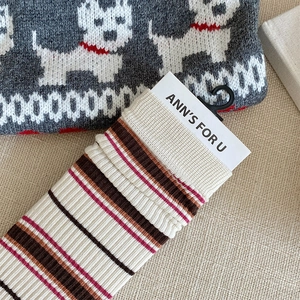 Detail of vintage striped knit socks with red and blue color blocking and logo tag