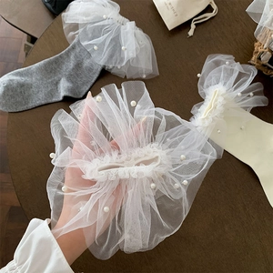 Gros plan détaillé de chaussettes Lolita en dentelle avec perles blanches et tulle
