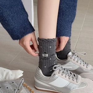 Detail of dark grey ribbed socks with white polka dots and cute cat embroidery