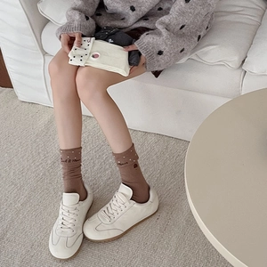 Detail of coffee brown polka dot socks with 'Sweet & Minor' strawberry embroidery