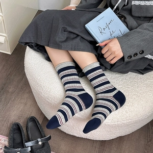 Dettaglio di calze a righe blu navy e grigie in misto cotone con polsini a coste