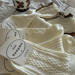 Detaillierte Strickmuster und braune Schleifen auf weißen Vintage-Crew-Socken