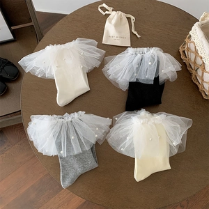Détail de chaussettes en dentelle Lolita avec perles en blanc, noir, gris et crème